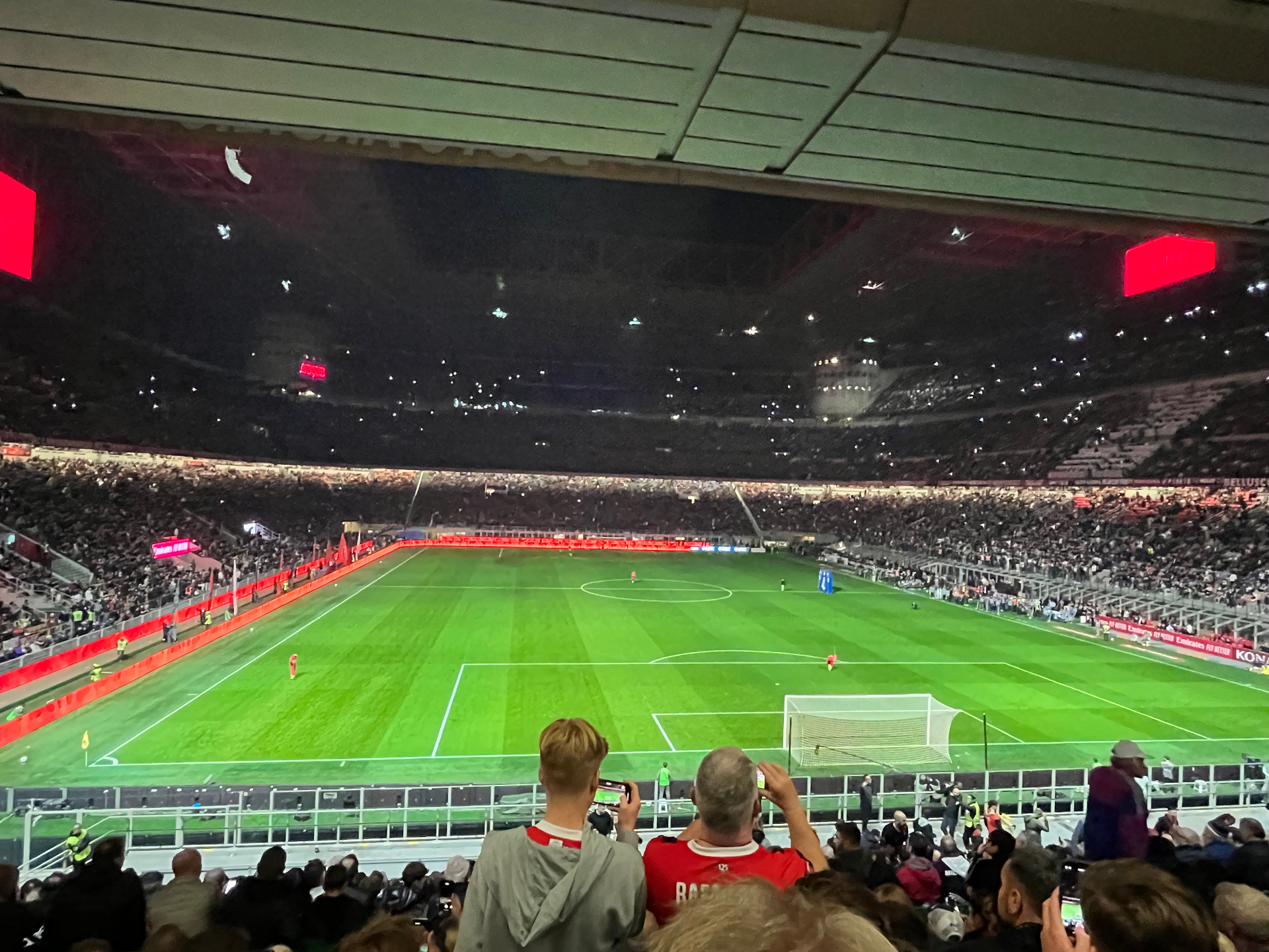Donker San Siro met telefoonlichtjes op de tribunes vlak voor de aftrap van AC Milan