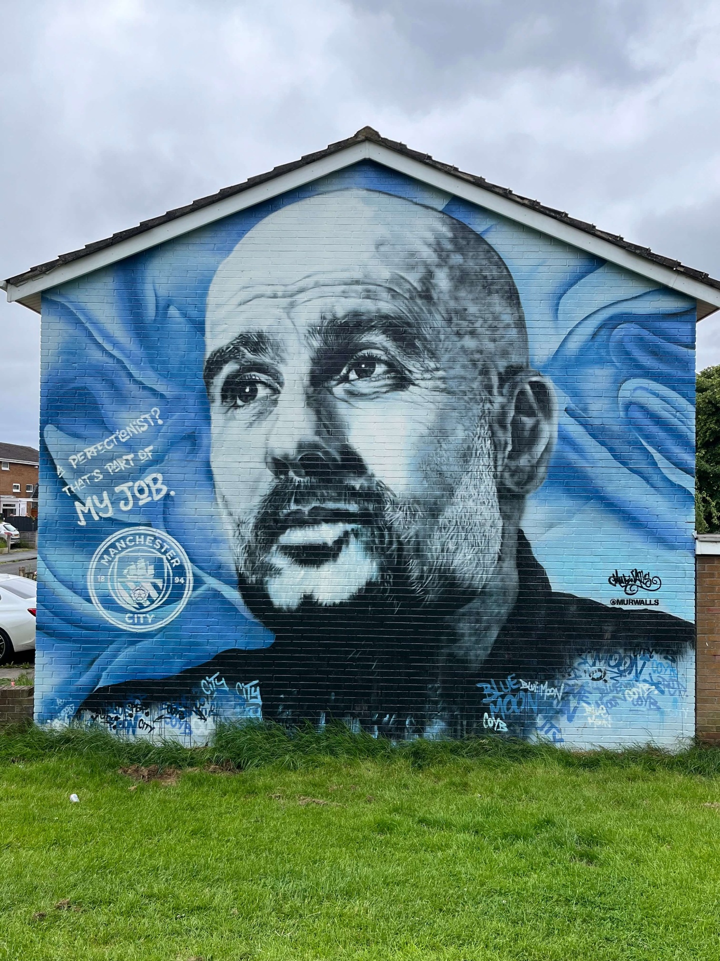 Muurschildering van Pep Guardiola in Manchester met Manchester City logo