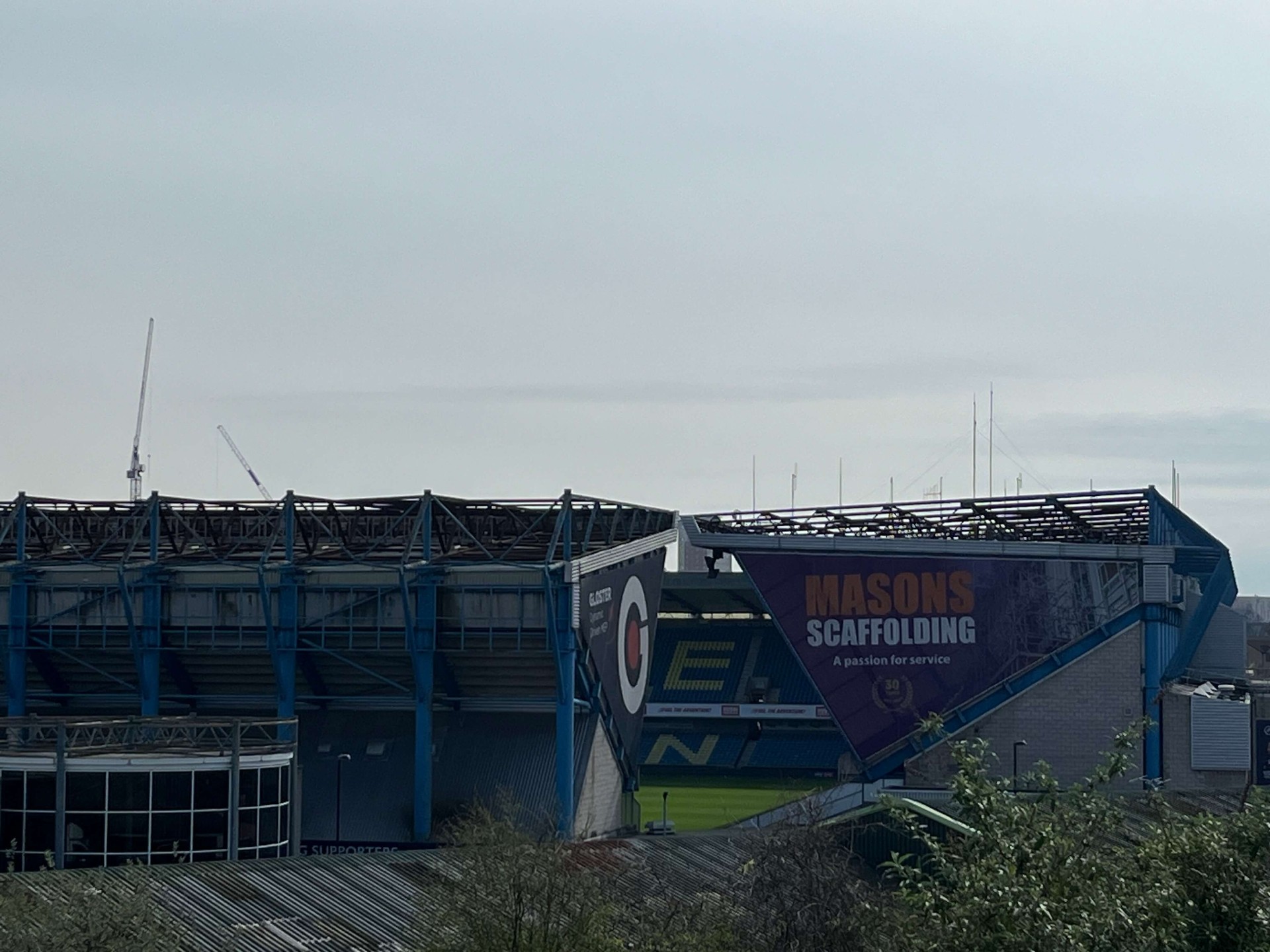 The Den vanuit de verte met de blauwe stalen constructie en COYL banners op de tribunes